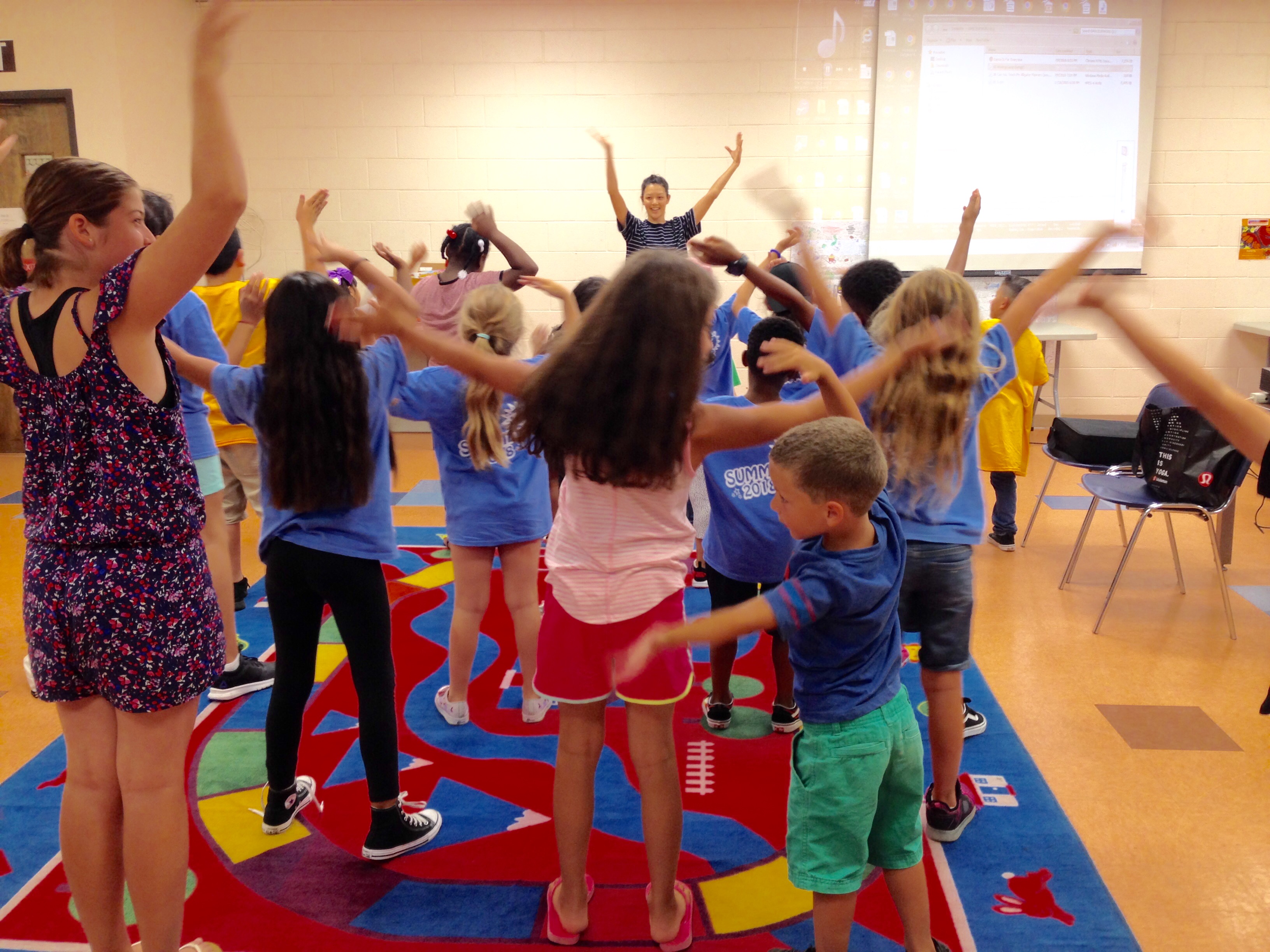 The children start “Dance Your Words” workshop with a warm-up exercise.